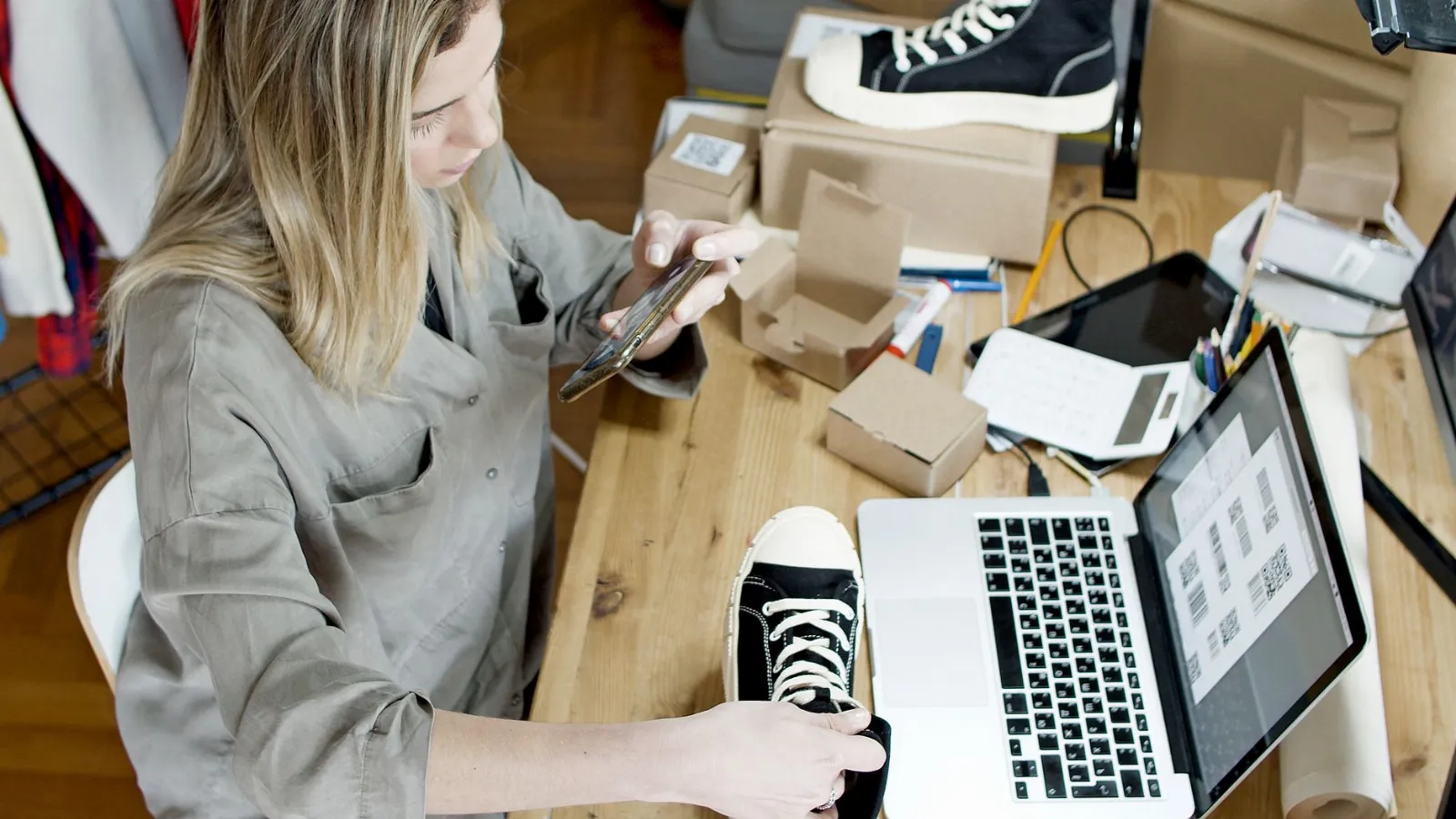 Alternativa a Kyte para vender por WhatsApp: vendedora fotografía un zapato con el celular para su catálogo